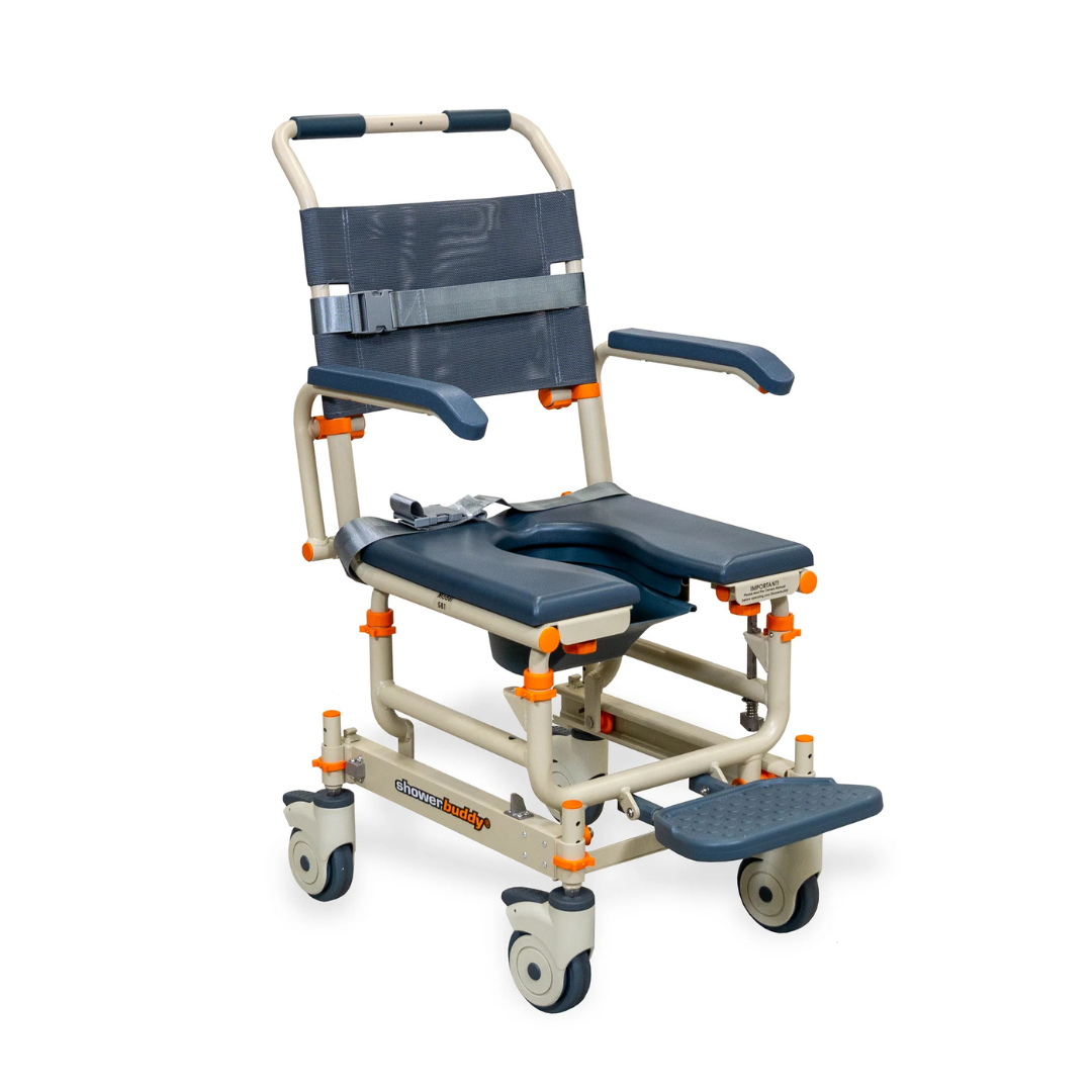 The ShowerBuddy® SB1 Transfer System is a mobile shower commode chair with a metal frame, padded seat and backrest, armrests, footrest, four casters, safety straps, and orange adjustment knobs for assisted bathing or toileting.
