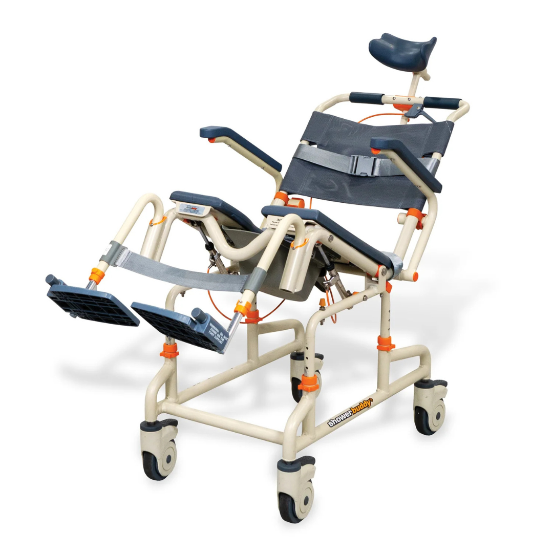 The ShowerBuddy SB3T Roll-In Shower Chair with Tilt Recline features a beige and gray design, adjustable headrest, backrest, leg supports, safety belts, and four caster wheels for improved comfort and mobility during showers.