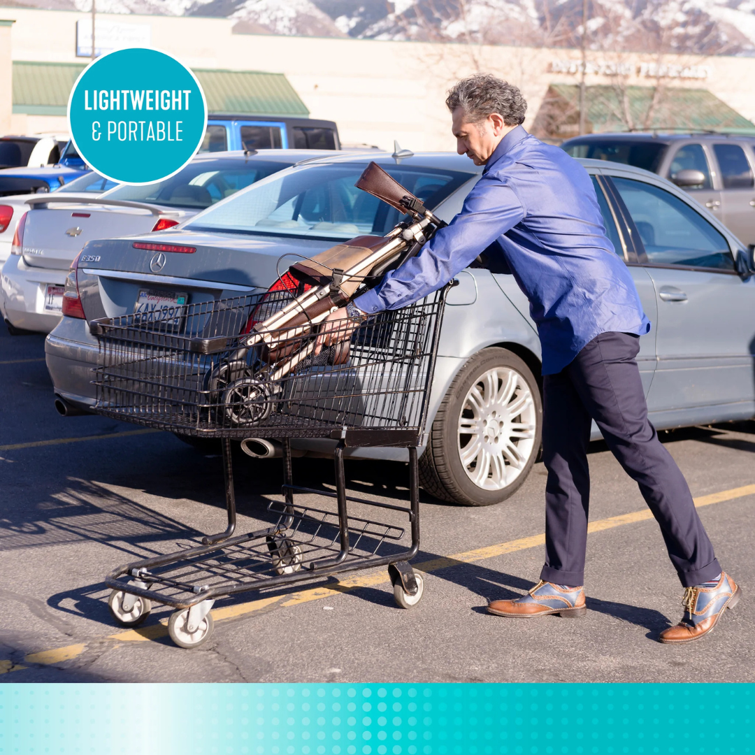 A man loads a folded Signature Life Elite Travel Rollator into a shopping cart in a parking lot. A blue circle in the top left reads Lightweight & Portable, with cars and mountains visible in the background.