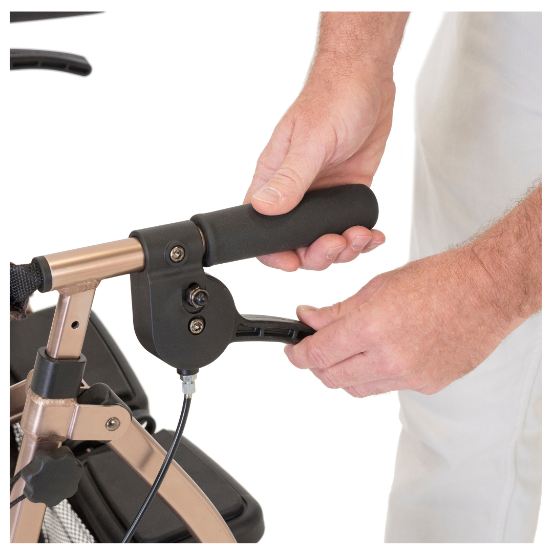 A close-up shows hands adjusting the handle of the Signature Life Elite Travel Rollator, highlighting its lightweight handlebar and control lever. The background is plain, with only the lower part of the person’s torso in view.