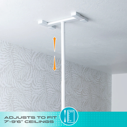 The Stander Double Handle Floor to Ceiling Grab Bar, shown in white and mounted on a patterned ceiling, features orange arrows for vertical adjustment and fits ceilings 7’–9’6” high.