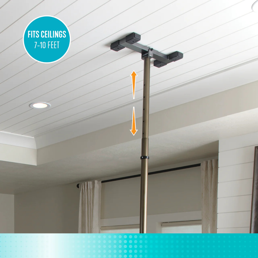 The Stander Wonder Pole Premium is a tension-mounted support pole for fall prevention, adjustable from 7 to 10 feet to fit most ceilings. Shown in a living room with white ceiling and curtains. Universal fit—also ideal for bathroom safety.