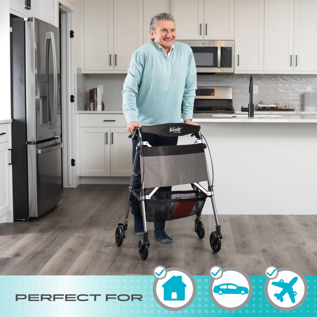 An older man smiles while using the Stander Wonder Rollator Plus in a modern kitchen. Icons below show it's perfect for home, car, and travel—making this compact folding rollator ideal for life on the go.