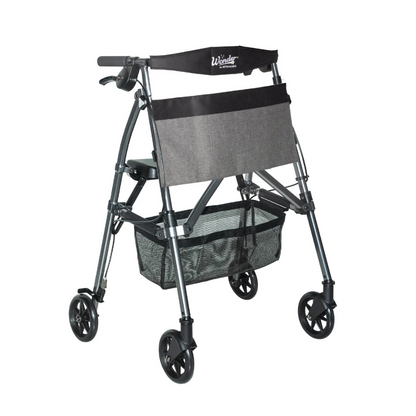 The Stander Wonder Rollator Plus is a lightweight, compact folding rollator with four wheels, a padded seat and backrest, hand brakes, large front storage pouch, mesh basket, and metallic gray frame—perfect for travel.