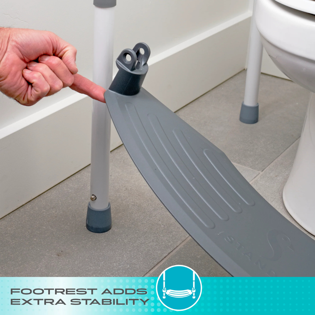 A hand shows attaching a gray footrest to the Stander Wonder Toilet Safety Rails & Standing Aid beside a toilet for added bathroom support. Bottom caption: FOOTREST ADDS EXTRA STABILITY.