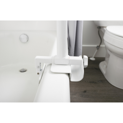 The Stander Wonder Bathtub Pole is securely clamped to the side of a tub near a toilet and shower curtain, providing sturdy fall prevention support for safe entry or exit.
