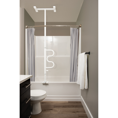 A bathroom with a white bathtub, curved shower rod and gray curtains, a Stander Wonder Bathtub Pole over the tub for fall prevention, a toilet, wall rack towel, and wood-style flooring.
