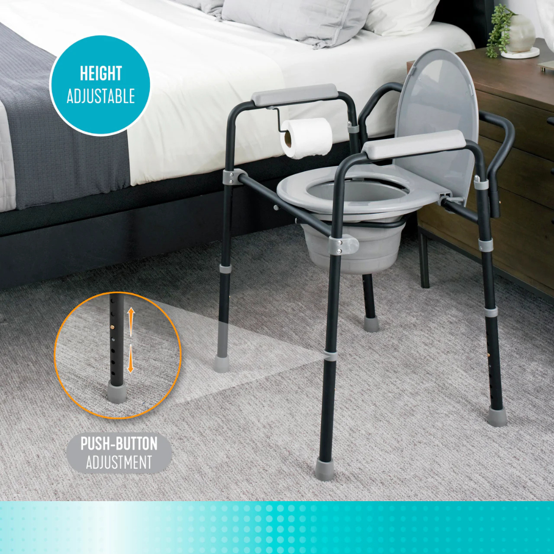 The Stander Universal Bedside Commode with TP Holder, shown by the bed, features a gray seat, armrests, a toilet paper holder, and space-saving push-button height adjustment on the legs.