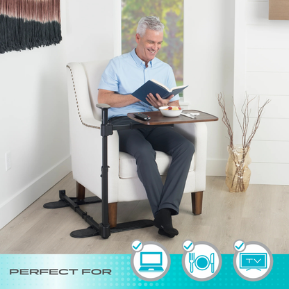 An older man sits in a white armchair, smiling as he reads and eats from his Stander Wonder Tray Plus – TV Tray & Standing Aid. Icons highlight its use for computers, dining, TV watching, and as a handy standing assist.