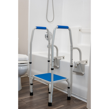The Step2Tub Bathtub Step Stool, featuring blue and white colors and handrails, is placed next to a bathtub in a bathroom with wood flooring and a nearby toilet to help prevent falls.