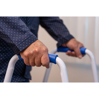 Close-up of a person gripping the handles of the Step2Bed Mini Bedside Stepper, highlighting its support and fall prevention features for safer bedside mobility.