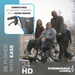 A man pushes a woman outdoors in a lightweight wheelchair, accompanied by two children. The text highlights, Unmatched attendant control with drum brake, and branding reads Strongback Mobility 24HD Heavy Duty Wheelchair. Be pushed with ease.