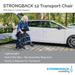 An elderly woman stands by a white car, folding the compact Strongback Mobility Excursion 12 Transport Wheelchair - Ultralight. Its lightweight, requires no assembly, collapses easily, and features ergonomic lumbar support for excellent spinal health.