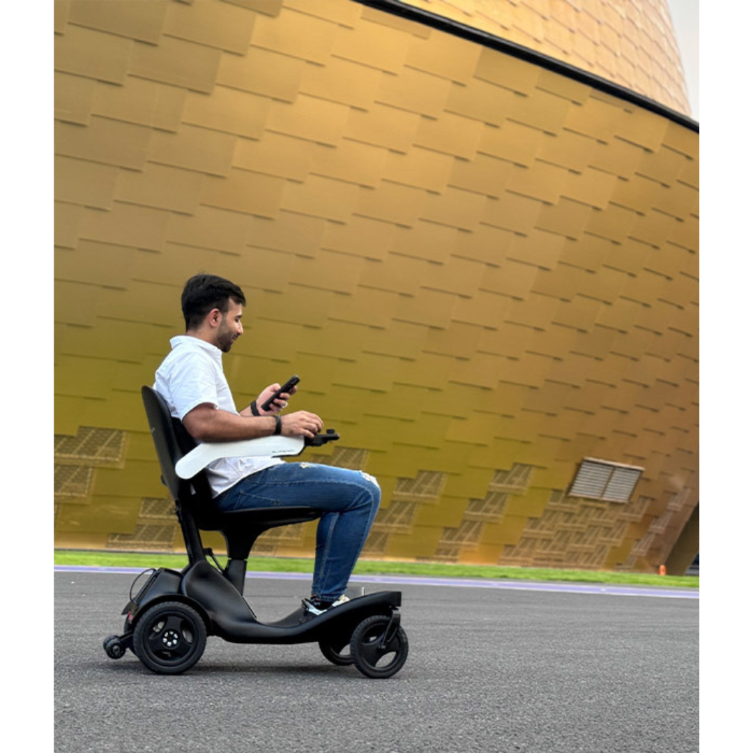 A man rides the Superpi P2 Portable Electric Wheelchair outdoors on a paved surface, passing a large gold building wall; however, the product description contains only CSS code and lacks relevant information for SEO keyword extraction.