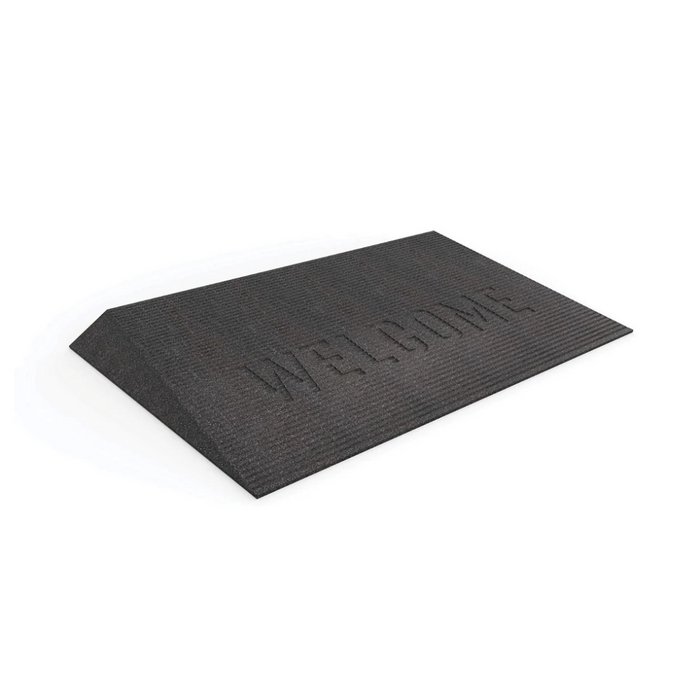 The EZ-Access TRANSITIONS® Angled Entry Welcome Mat, placed on a white background, features a black raised texture with WELCOME embossed on it. It provides a slip-resistant surface for any entryway, ensuring both safety and style as you enter your home.