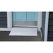 A light blue door with a silver threshold is set between dark gray siding walls. The EZ-Access TRANSITIONS® Modular Entry Ramp provides a wheelchair-accessible, slip-resistant aluminum surface on the concrete leading to the door.
.