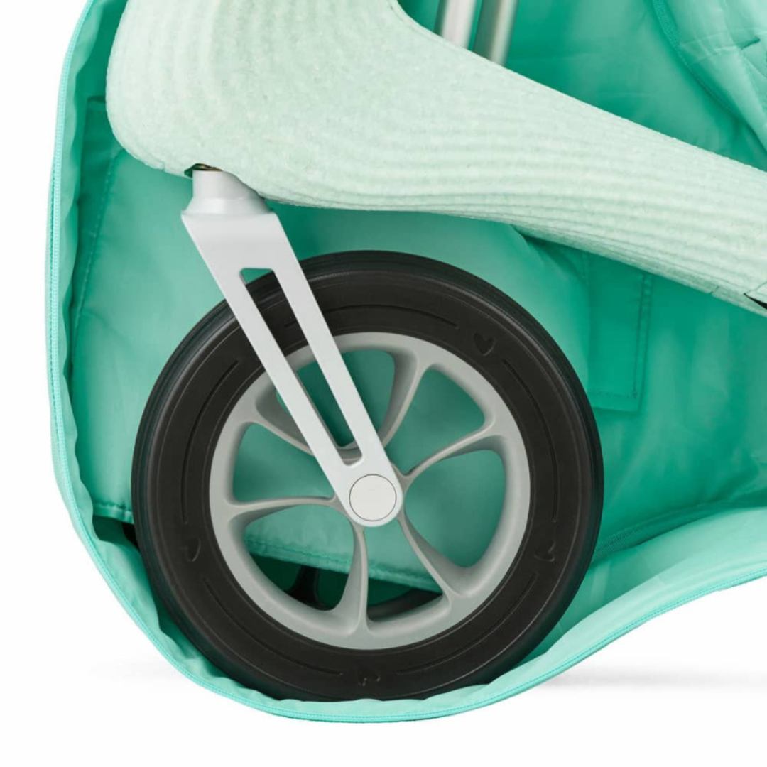Close-up of a black and gray stroller wheel attached to a mint green byACRE Nordic Pioneer rollator, partially covered by the Travel Bag For The byAcre Nordic Pioneer Rollator for extra protection.