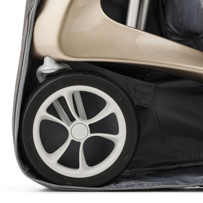 Close-up of a ByAcre Ultralight Carbon Fiber Rollator wheel with a white rim inside the gray Travel Storage Bag, showing the lower frame and zipper edge.