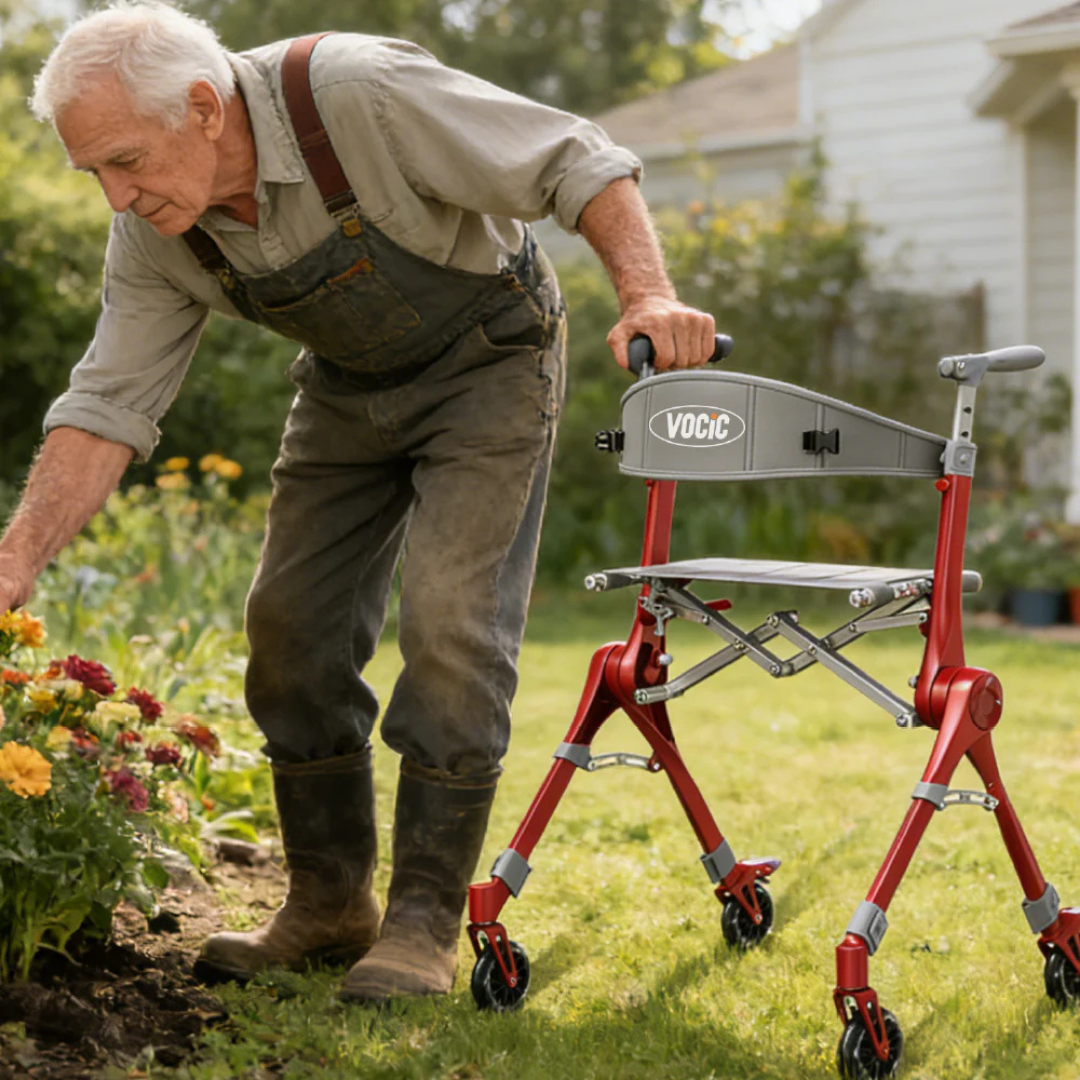 An elderly man in overalls tends to flowers in a garden, using a red and silver Ultra-Compact PackGo Rollator Walker with Backpack | VOCIC Z35 for support on a sunny day in front of a house.
