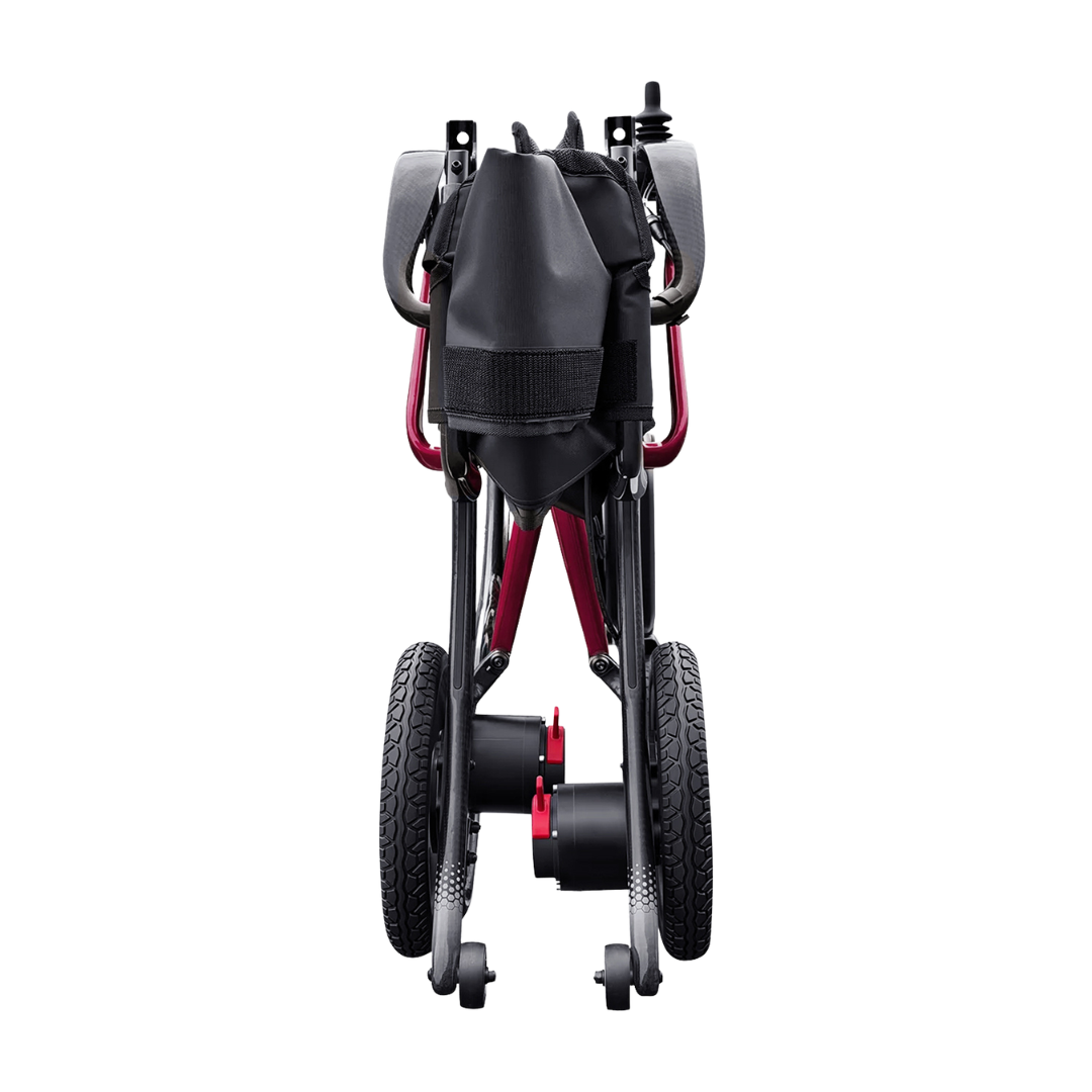 A rear view of the folded Forcemech Ultralite G20 PRO Carbon-Fiber Power Wheelchair in black and red displays its wheels, carbon-fiber frame, and a black storage pouch attached to the back, all set against a white background.