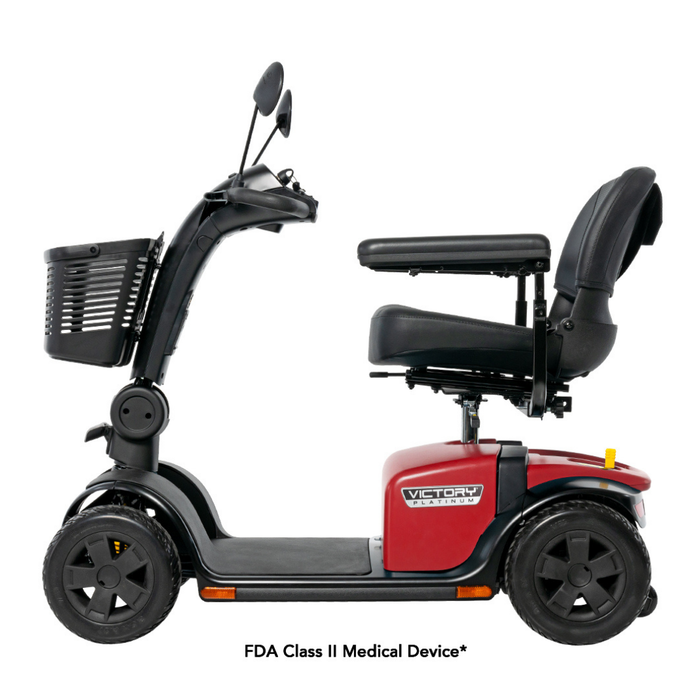 Side view of a red and black Pride Mobility Victory® Platinum Bariatric 4-Wheel Scooter with padded seat, armrests, backrest, front basket, mirrors, and four wheels with EZ Turn Technology. Text: “FDA Class II Medical Device.”.