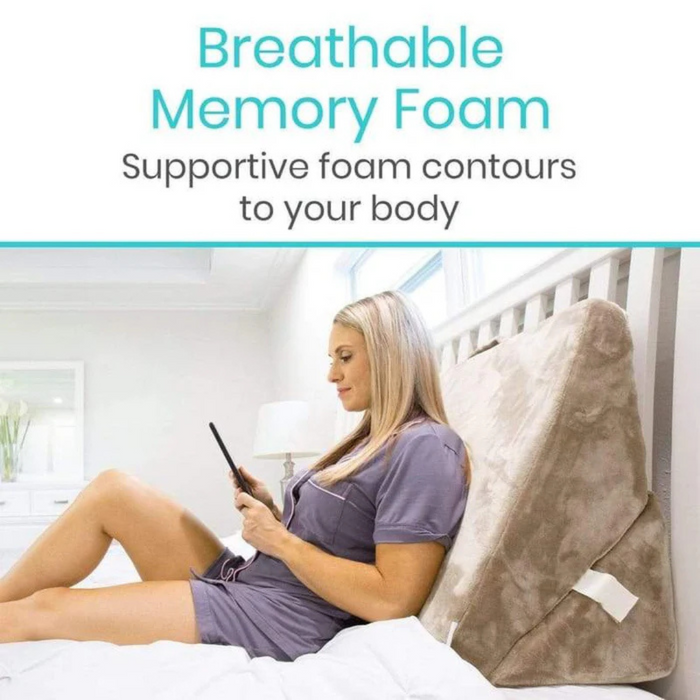 A person in purple pajamas sits on a bed, leaning against the Vive Health Foam Bed Wedge - 3-in-1 Wedge Design made of breathable memory foam. They hold a tablet while the text above reads, Supportive foam contours to your body.