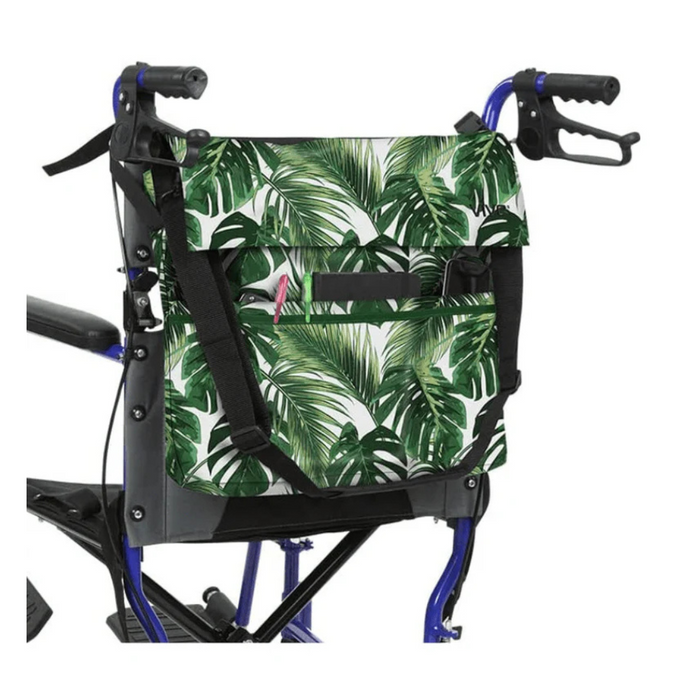 A wheelchair with the Vive Health Portable Mobility Bag, featuring a green and white tropical leaf pattern made of waterproof nylon, is attached at the back using adjustable straps. It has black handles and a striking blue frame.