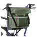 A vibrant green Vive Health Portable Mobility Bag with adjustable straps, made from waterproof nylon, is attached to a blue walker. It has multiple pockets for pens and a small notebook, with vive elegantly printed on the bag.