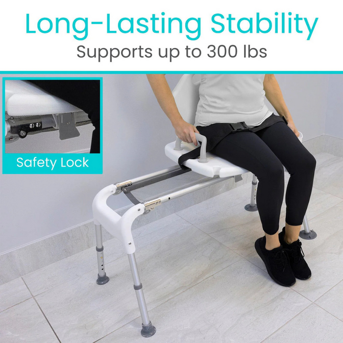 Seated on the Vive Health Sliding Bathtub Transfer Bench, a person in black pants and shoes is in the bathroom. The white chair made of rust-resistant aluminum supports up to 300 lbs, features a safety lock, and includes a strap for extra security.