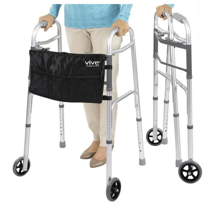 A person using a Vive Health Folding Walker with 5 wheels crafted from lightweight anodized aluminum and a black storage pouch. This foldable walker features four legs, two with wheels, and adjustable handles for support. The person is wearing beige pants and brown shoes.