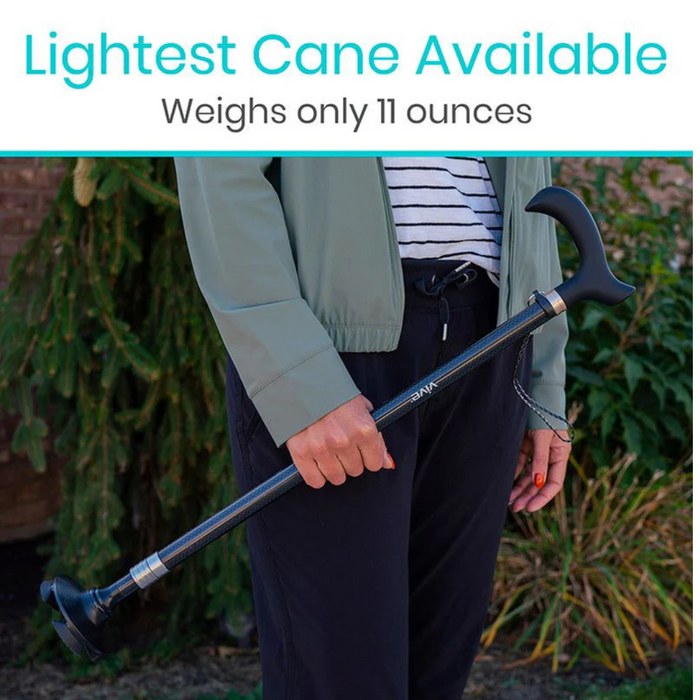 A person using the Vive Health Carbon Fiber Standing Cane, which weighs only 1 lb, is outdoors with a curved handle. The individual wears a light green jacket and black pants. Text above says: Lightest Cane Available.