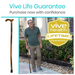 A man in a green polo and khaki pants stands in a garden holding the Vive Health Wooden Cane with Ergonomic Handle. The text reads, Vive Life Guarantee. Purchase now with confidence, and a yellow badge states Vive Health Lifetime Guarantee.