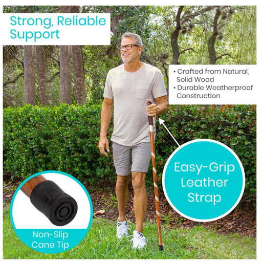 A man uses the Vive Health Carved Wooden Walking Stick on grass, showcasing a non-slip rubber tip and easy-grip leather strap. Made from natural solid wood, it offers strong, reliable support and durable, weatherproof construction. Trees and bushes fill the background.