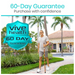 An older man strolls down a paved path holding a Vive Health Carved Wooden Walking Stick, its willow bark design adding elegance amidst the palm trees and greenery. A house is in the background, featuring a large emblem stating 60-Day Guarantee above Purchase with confidence.