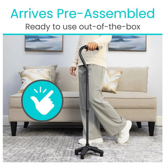 A person holds the Vive Health SureWalk Stand-Alone Quad Cane in black, featuring an ergonomic handle, in front of a beige couch with decorative pillows. The text above reads Arrives Pre-Assembled, Ready to use out-of-the-box. A graphic shows a hand with a check mark emphasizing its heavy-duty aluminum build.