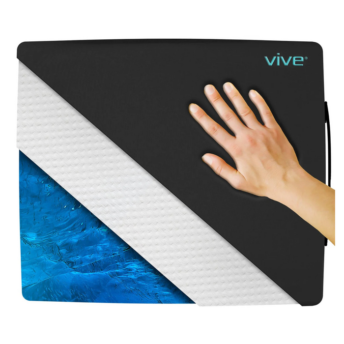 A persons right hand touches a black Vive Health orthopedic gel seat cushion, revealing the premium foam and blue layers. This cushion is ideal for tailbone pain relief and features the brand name Vive in the top right corner.