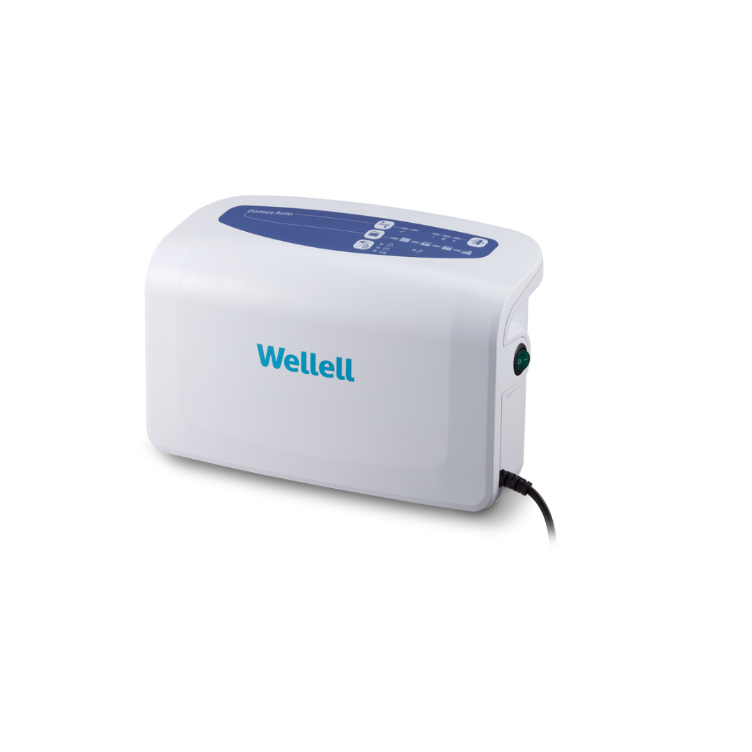 The Wellell Domus Auto G2 Bariatric Alternating Pressure and Low Air Loss System is a white medical device with a blue control panel, indicator lights on top, and a right-side power cord, designed for pressure ulcer prevention.