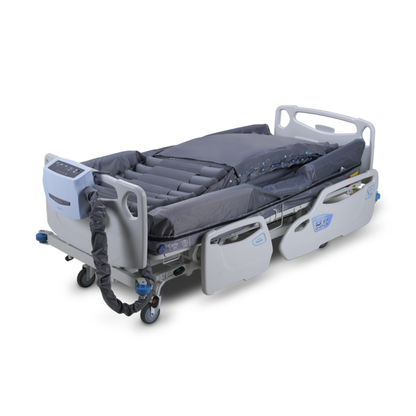 The Wellell Optima Turn Automated Lateral Rotational Pressure Relief System hospital bed, shown against a white background, features side rails, wheels, an air mattress with segmented chambers, and a foot-end control panel for pressure injury prevention.