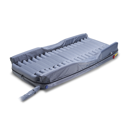 The Wellell Optima Turn Automated Lateral Rotational Pressure Relief System is a grey inflatable mattress with horizontal air chambers, attached hoses, and a cover, ideal for hospital or home care to help prevent pressure injuries.