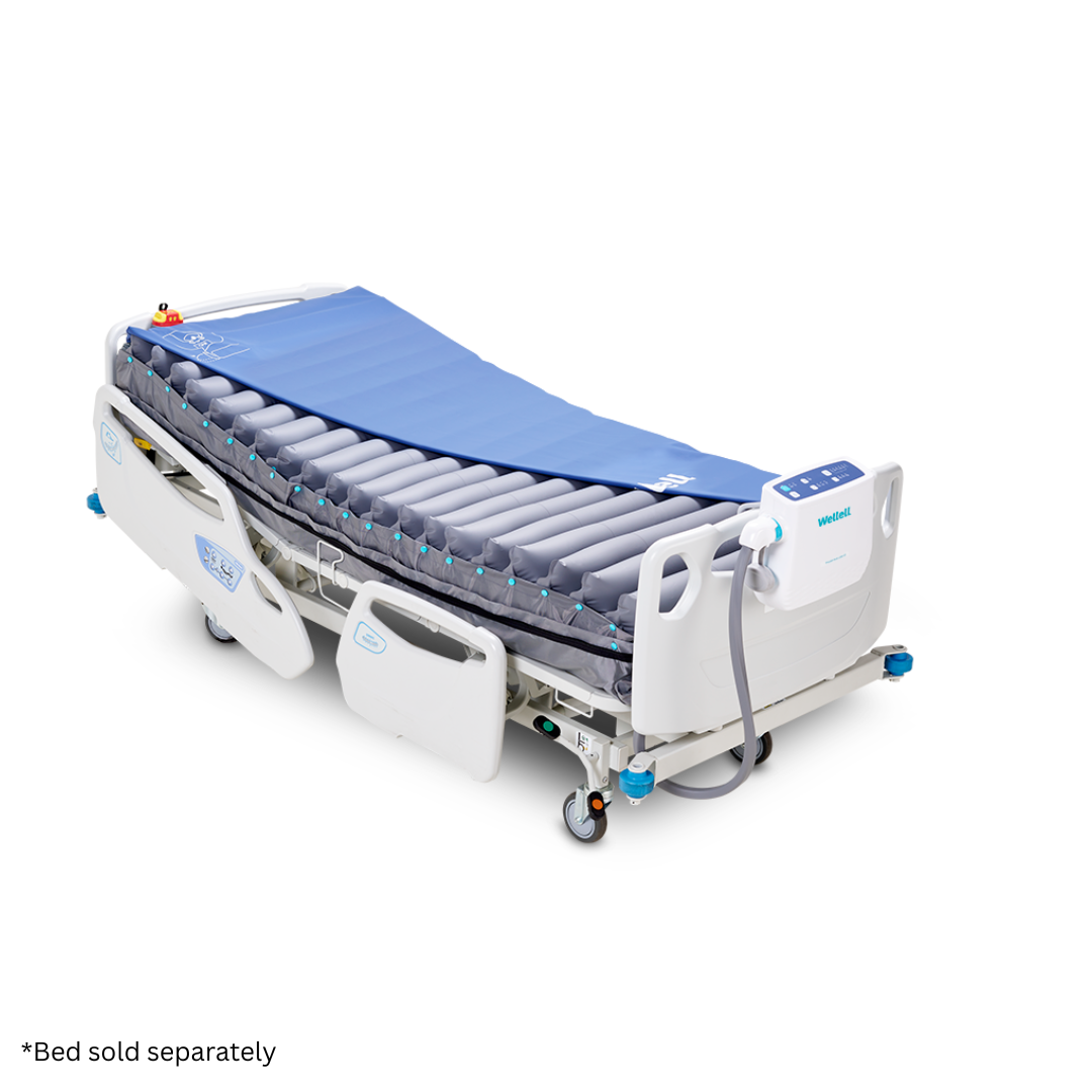 Hospital bed with a Wellell Procare Auto G3 Hospital Air Mattress System in blue and an attached electronic control unit; the mattress features segmented air chambers, exemplifying advanced air mattress technology. Text reads, *Bed sold separately.