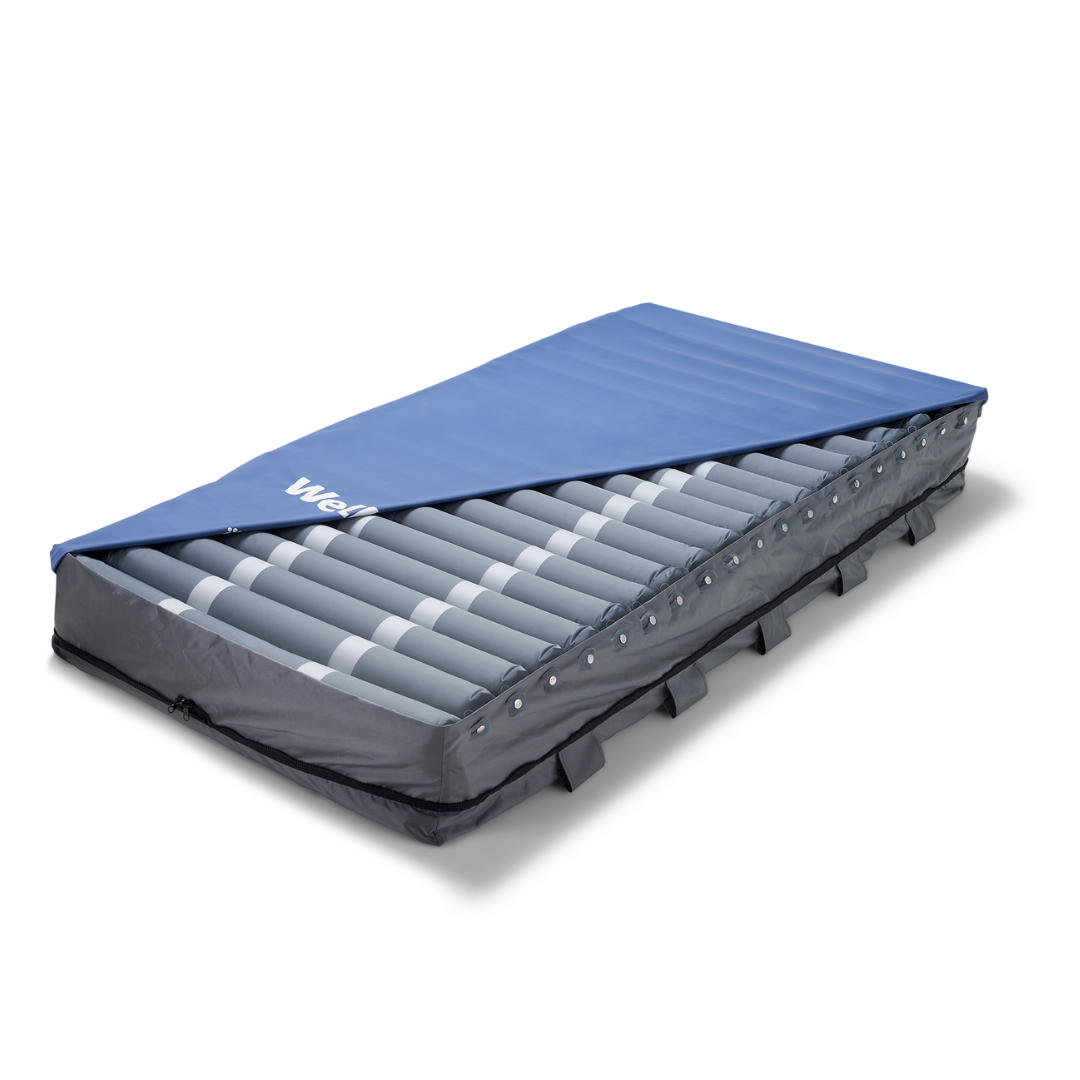 The Wellell Serene Air Alternating Pressure Mattress with True Low Air Loss features alternating air tubes and blue fabric to help prevent pressure injuries and support patients during post-acute care.