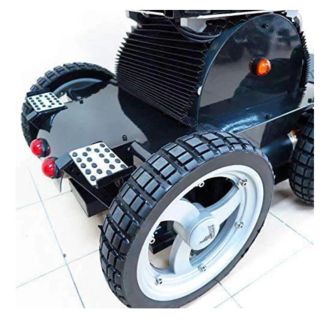 A close-up of the Wheelchair88 All-Terrain Stair Climbing 4x4 Recreational Electric Vehicle shows its black body, large treaded tires, metallic footrests, rear red lights, and ribbed top component on a tiled floor—resembling an all-terrain power chair.