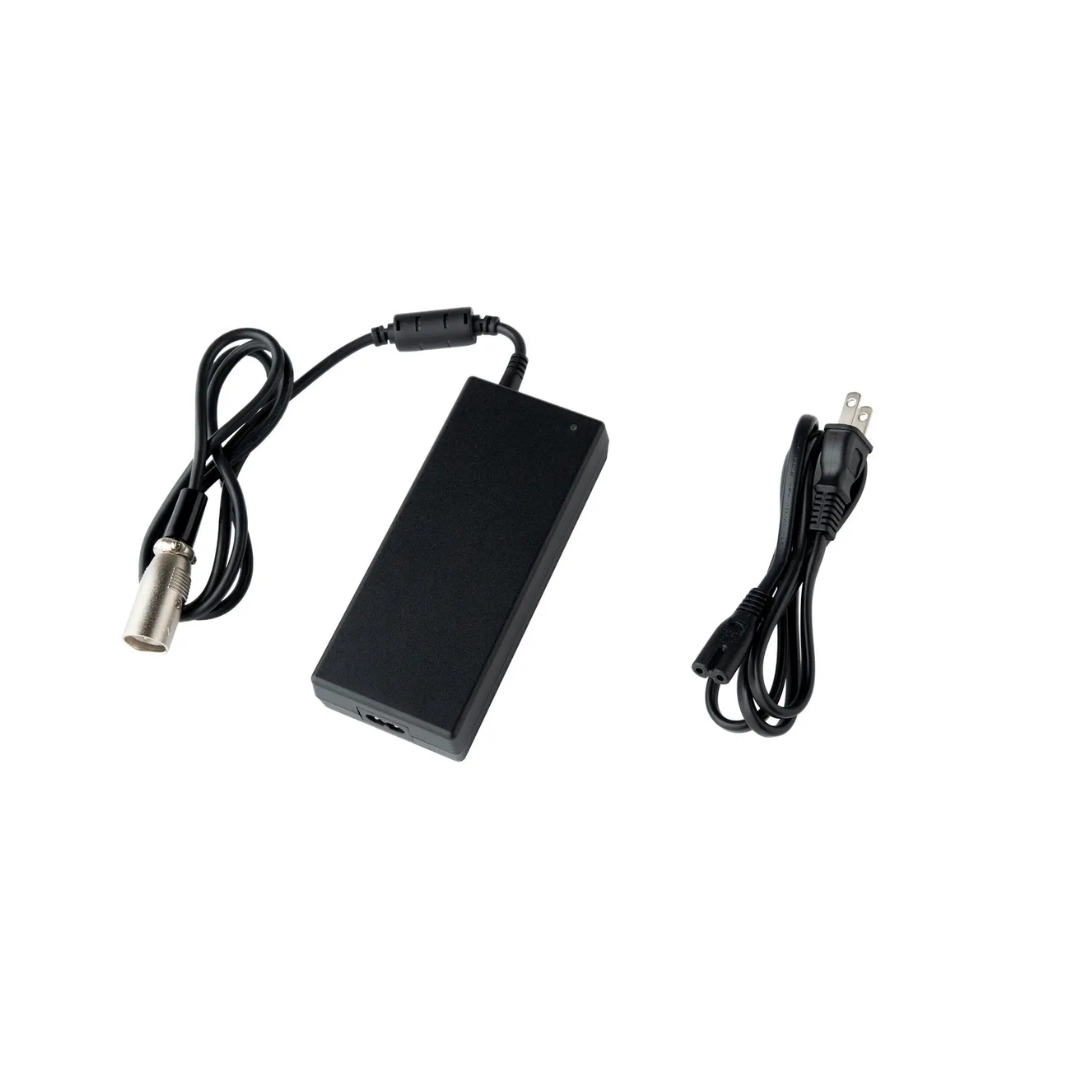 A Whill Battery Charger for WHILL Model C2, F, and R is shown on a white background, featuring two cables: one with a three-prong AC plug and another with a round metal connector.