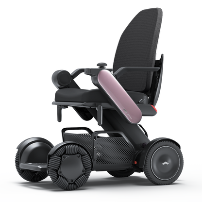 The Whill Model C2 High Back Smart Power Chair with RC App Control, in black, features large distinctive wheels, a mesh backrest, and a sleek curved pink side panel, showcased against a plain white background for clear presentation.
