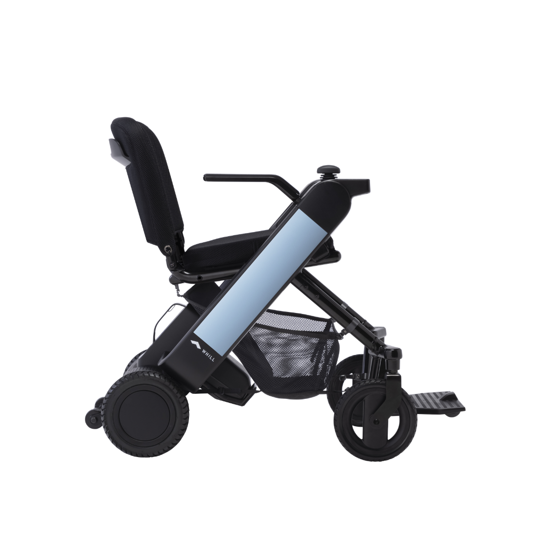 Side view of the Whill Model F Lightweight Portable Electric Wheelchair featuring a black frame, light blue side panel, cushioned seat and backrest, armrests, mesh storage basket, and large rear wheels. Check specifications and warranty for details.