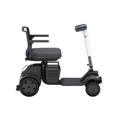 The Whill Model R 4 Wheel Portable Scooter features a modern, compact design with a dark seat, backrest, and armrests, a flat footrest area, and a slim upright steering column—shown from the side against a white background.