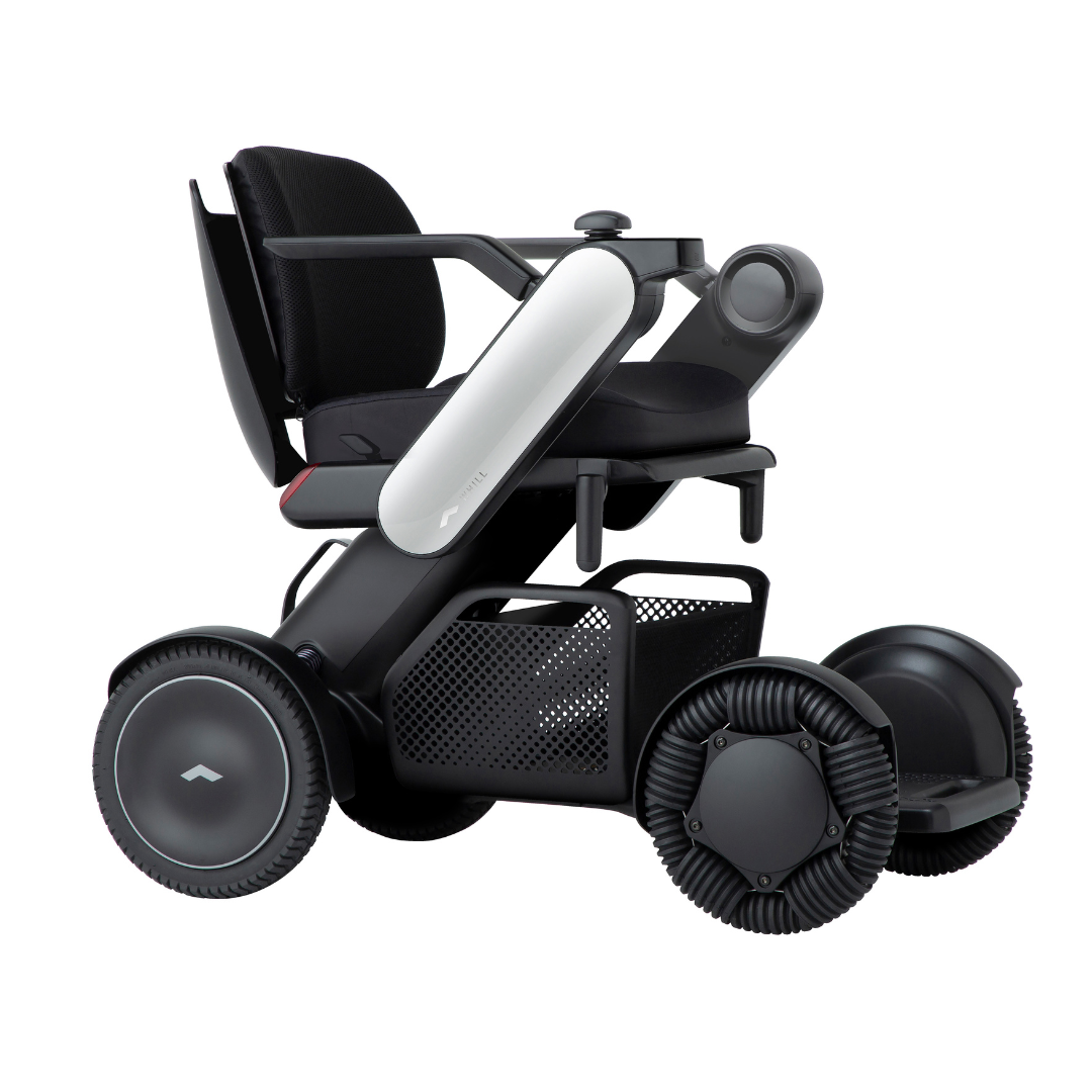 The Whill Model C2 Smart Power Chair is a compact, portable mobility device featuring large wheels, a black seat, armrests, storage basket, modern design, advanced technology, and ergonomic comfort. This is a Class II medical device.