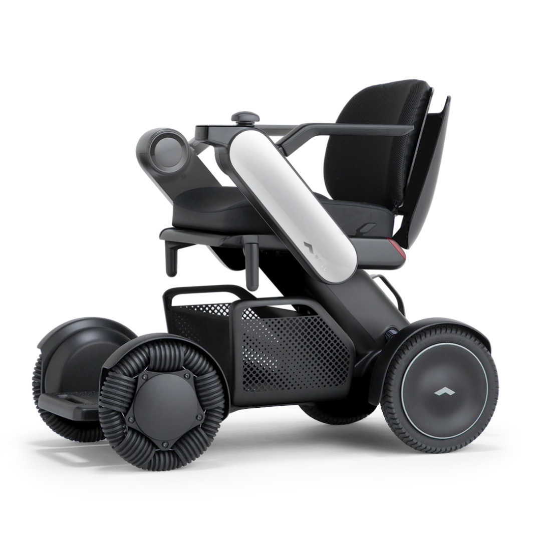 The Whill Model C2 Smart Power Chair - Compact Portable Mobility offers a modern black and gray design with rugged wheels, ergonomic seat, and armrests, delivering enhanced comfort and mobility as a Class II medical device.