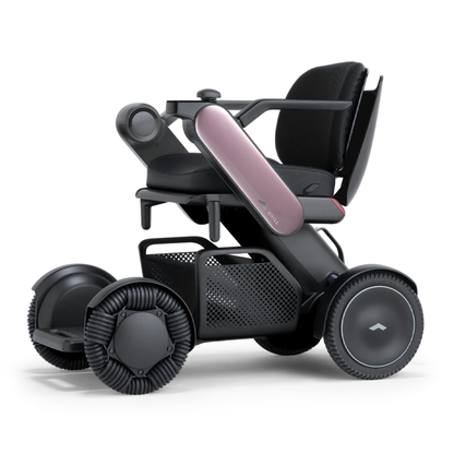 The Whill Model C2 Smart Power Chair is a modern, compact mobility device with a sleek black and pink frame, mesh side storage, unique all-direction wheels for easy indoor use, and is FDA-compliant as a Class II medical device.