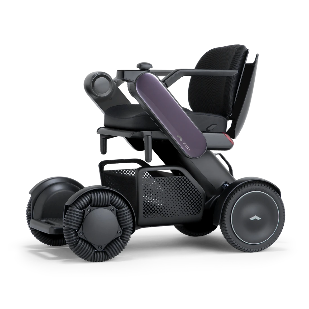 The Whill Model C2 Smart Power Chair—a compact, portable mobility device—features large, unique wheels, a mesh storage basket, and a sleek black and purple design. Shown in side view on white. This Class II medical device meets FDA compliance standards.